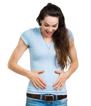 A happy newly pregnant woman smiling and looking and holding tummy. Isolated on white.