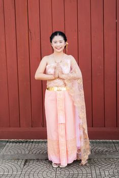 Asian Thai woman/bride in Thai wedding suit is paying respect in Thai style.