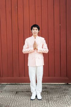 Asian Thai man/groom in Thai wedding suit is paying respect in Thai style.