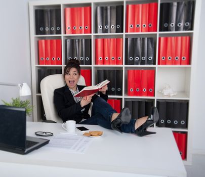 business woman with diary with his legs on the table