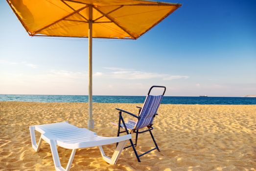 chairs and umbrella on empty beach