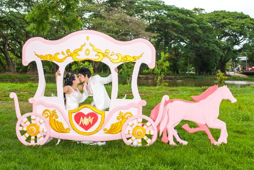 Asian Thai bridal is kissing in romantic carriage with love theme as the Prince and Princess.