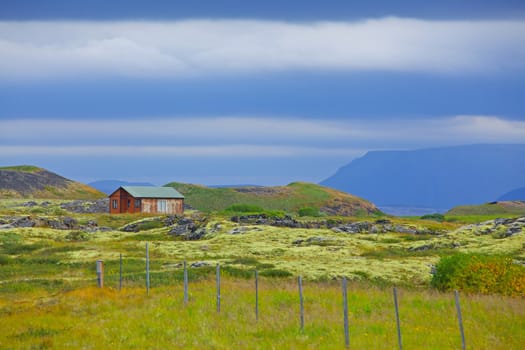 Beautiful house in Iceland. Mountains in background.