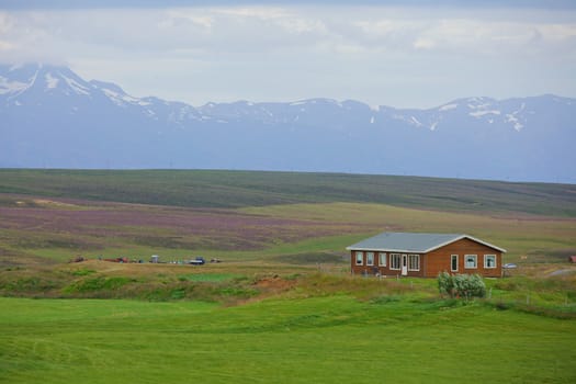 Beautiful house in Iceland. Mountains in background.