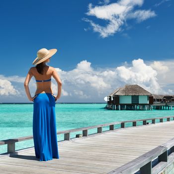 Woman on a tropical beach jetty at Maldives