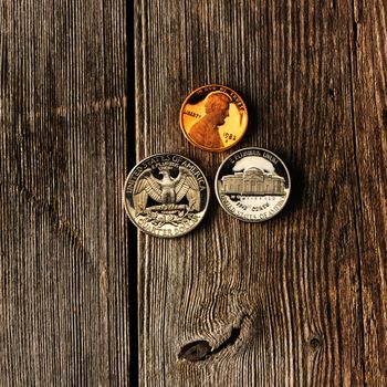 Three US cent coins over wooden background