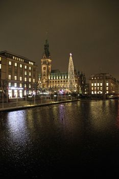 Night scene of downtown Hamburg in Germany with the illuminated buildings reflected in the water of the River Elbe