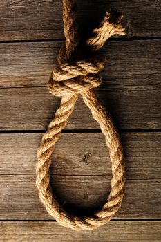 Rope noose with knot over old wooden background