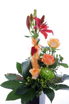 Formal floral wedding arrangement with colourful flowers including roses and tiger lilies with a base of greenery and a red heart