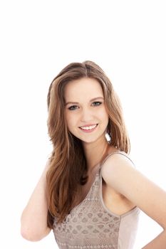 Pretty teenager with an engaging smile and long brunette hair standing looking at the camera, head and shoulders portrait isolated on white