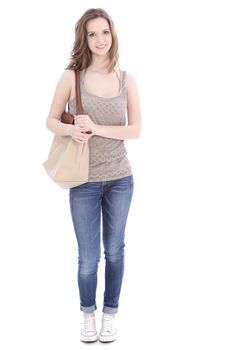 Trendy young female student wearing jeans and a pretty summer top and carrying a large cloth bag over her shoulder, full length portrait on white