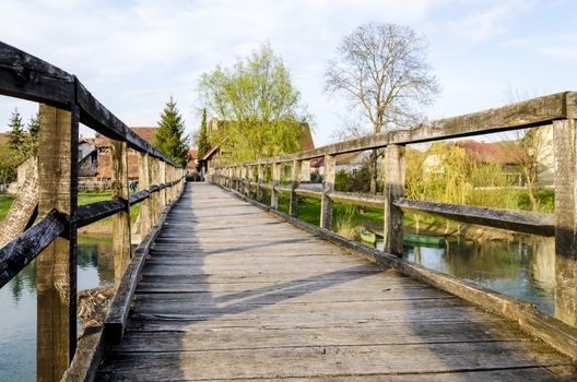 Old wooden bridge for pedestrians in Kostanjevica na Krki, Slovenia, Europe.