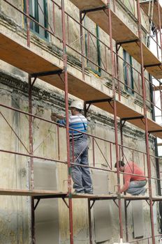 LJUBLJANA, SLOVENIA -APRIL 22: Two masons on scaffold during early stage of facade restoration, April 22, 2013 in Kostanjevica na Krki, Slovenia. 