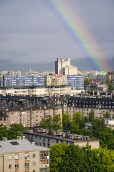 View over Ljubljana districts with rainbow casted in the sky.