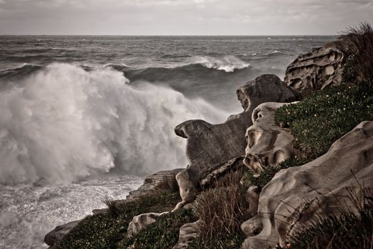 Stormy seas breaking on interesting rock formations during a cyclone on Bondi Beach in Sydney, Australia