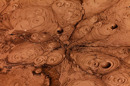 Background texture pattern of bubbling hot mud that boils up due to geothermal volcanic geyser activity