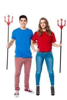 Young couple holding devil forks, halloween concept