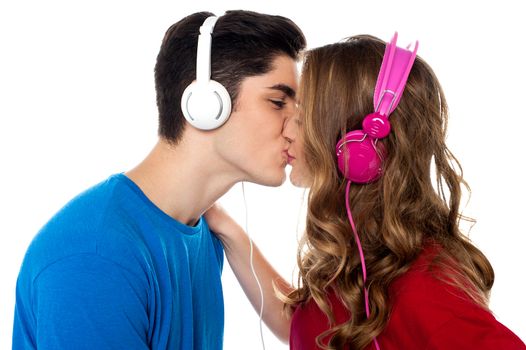 Love couple tuned into musical world and kissing each other