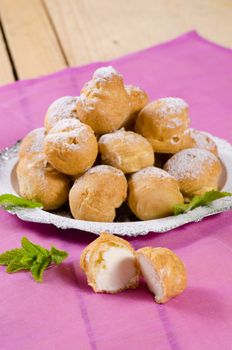 Heap of freshly made profiteroles on a dessert plate