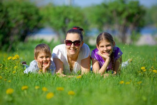 Happy young mother with her children have fun at beautiful park outdoor in nature