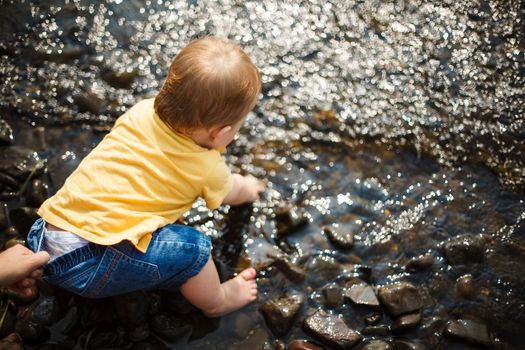 Baby sitting in shallow water in a lake