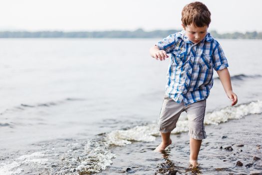 Boy walking in shallow water in a lake