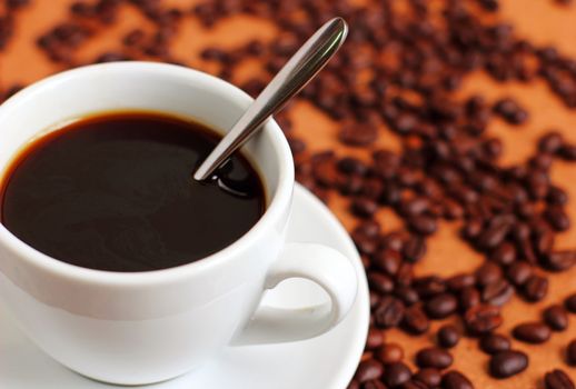 Cup of coffee with coffee beans and spoon