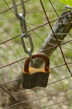 closed rusty padlock on the fence