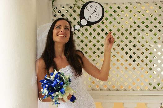 Young woman in wedding dress posing with thought bubble "I'm married"