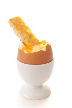Boiled egg in a cup holder with a buttered toasted soldier