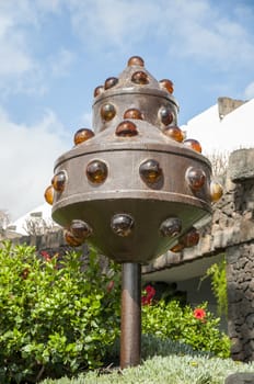 strange monument in the garden next to a house