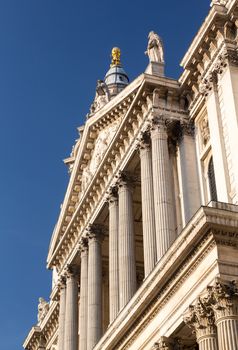 Perspective view of the west front of St Pauls Cathedral in London England at dusk as the sun is setting low in sky.