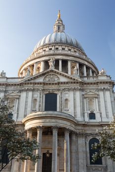 West front of St Pauls Cathedral in London England at dusk as the sun is setting low in sky.