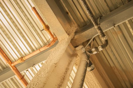 exposed underside of steel floor or roof deck with utilities and spray-on fireproofing