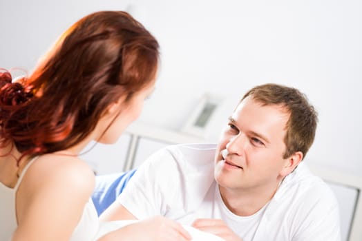 young man lying in bed with his girlfriend, spend time together at home