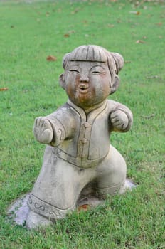 Traditional child Chinese style statue on the grass in garden