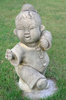 Traditional child Chinese style statue on the grass in garden