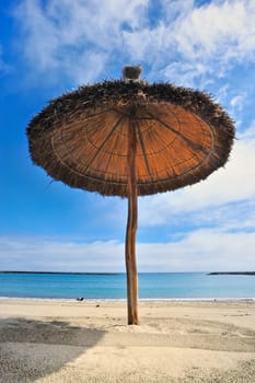 Straw parasol on the sandy sea beach