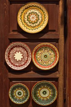 Painted pottery dishes in oriental style at wooden stand