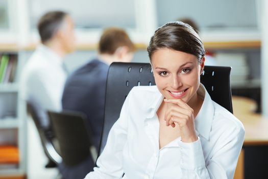 Happy businesswoman with colleagues in the background