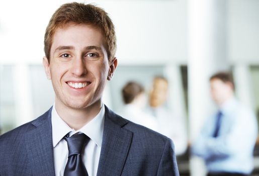 Young businessman with colleagues in the background