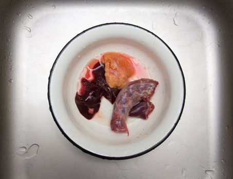 meat in a dish on a metal background with water drops