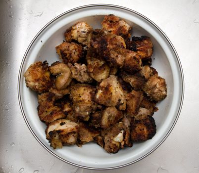 meat in a dish on a metal background with water drops