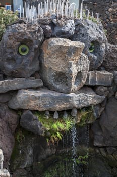 Memorial stone faced spewing water