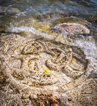Rock carvings on the beach (symbol of two fish) near Sevastopol (Crimea), Ukraine, May 2013
