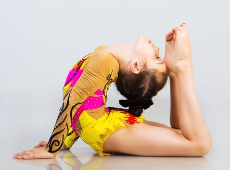 little girl gymnast on a light background