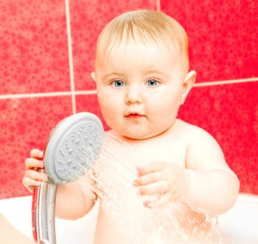 beautiful smiling baby in bath with shower
