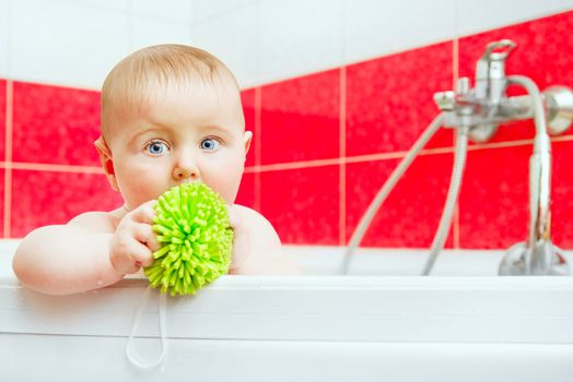 cute smiling baby in bath with green wisp