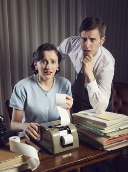 Scared man and woman looking at their bills in the living-room at home