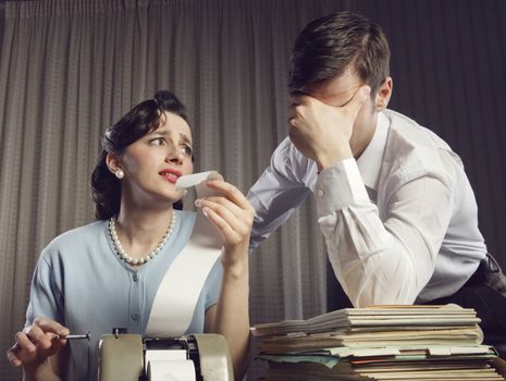 Stressed man and woman looking at their bills in the living-room at home